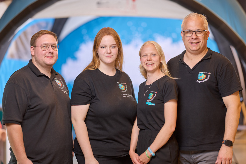 jrk-nds_Landesleitung_Gruppe Die Landesleitung des JRK Niedersachsen vor blauem Hintergrund
