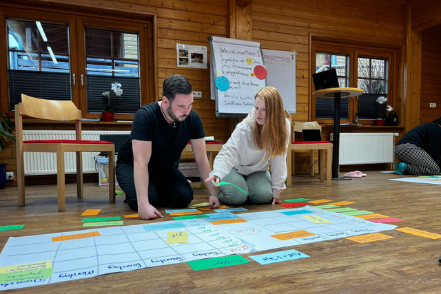 Zwei Juleica-Teamende arbeiten an einem Flipchart.