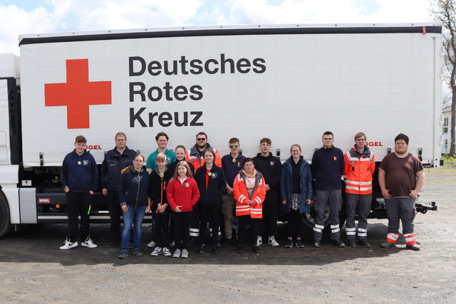 Mitglieder des Jugendrotkreuzes und der Fachdienstbereitschaft vor einem LKW mit dem Logo des Deutschen Roten Kreuzes