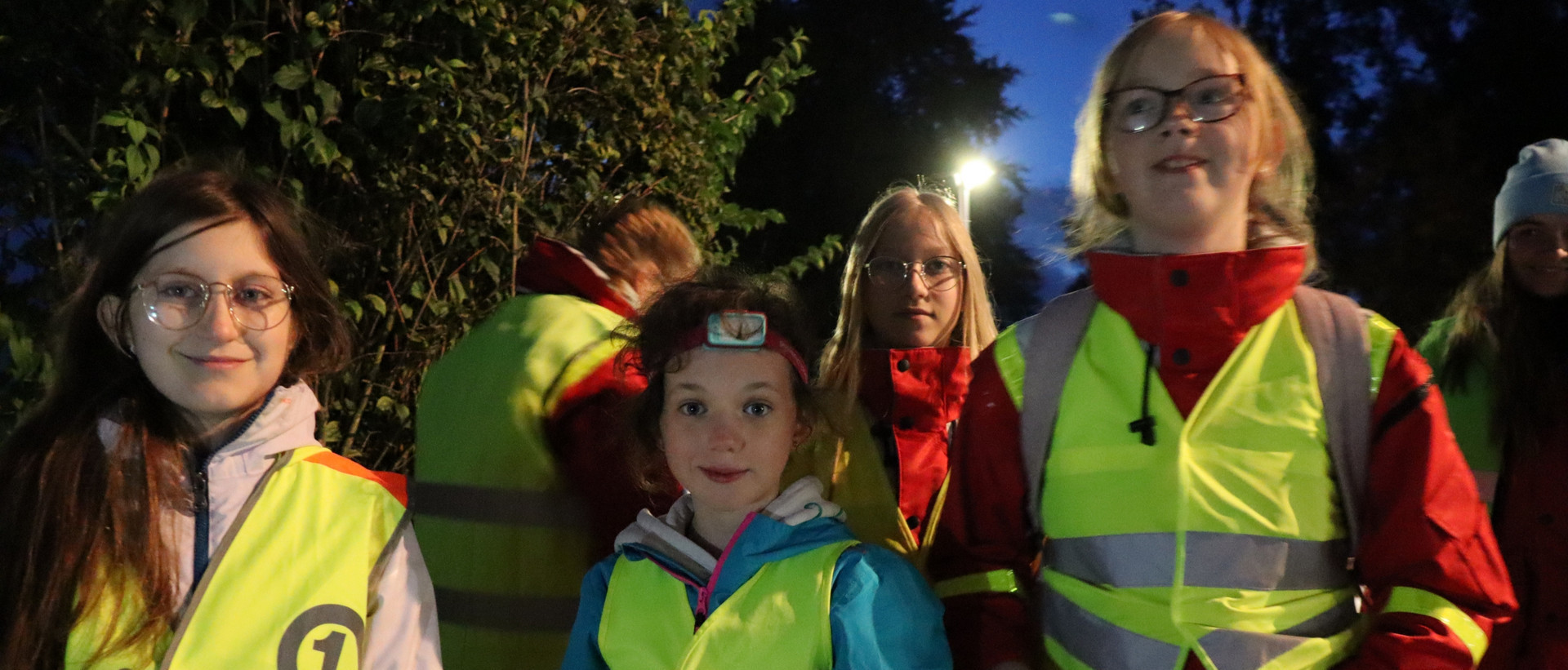 jrk-nds_abendorienterungslauf_titelbild.jpg JRK-Kinder in Warnwesten sind im Dunkeln unterwegs bei einem Abendorientierungslauf